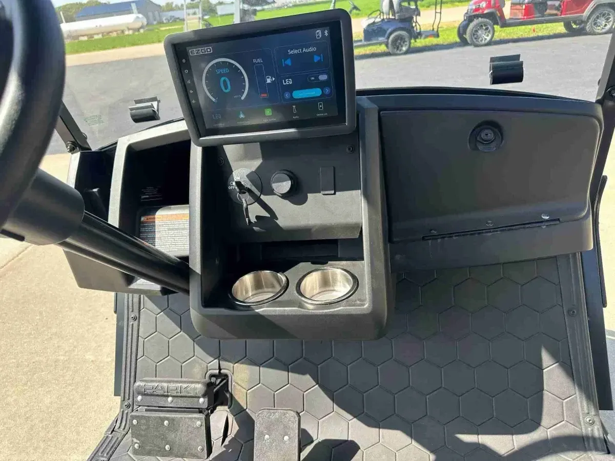 Dashboard with 10-inch ECOXGEAR touchscreen and cup holders on the 2027 E-Z-GO Express 4 Summit XT