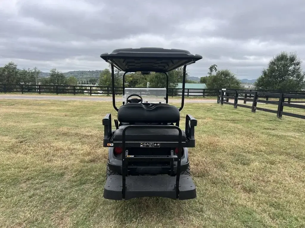 Rear view of the E-Z-GO Express 6 Summit X showing the rear-facing seat and grab bar