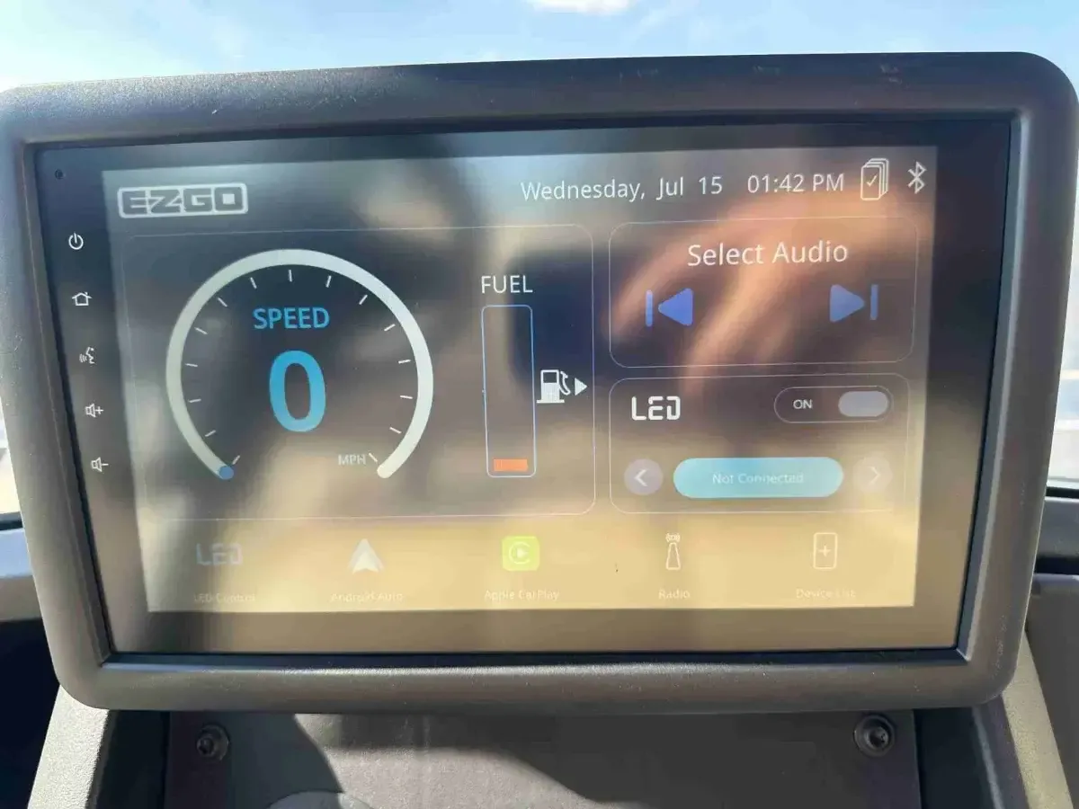 E-Z-GO Intelliscreen touchscreen showing speed, fuel level and audio controls
