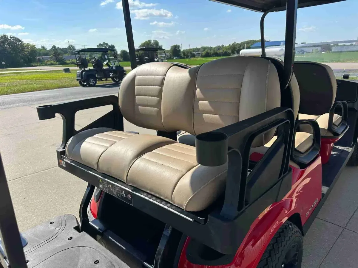 Rear-facing tan seat with armrests and cup holder on the E-Z-GO Express 6