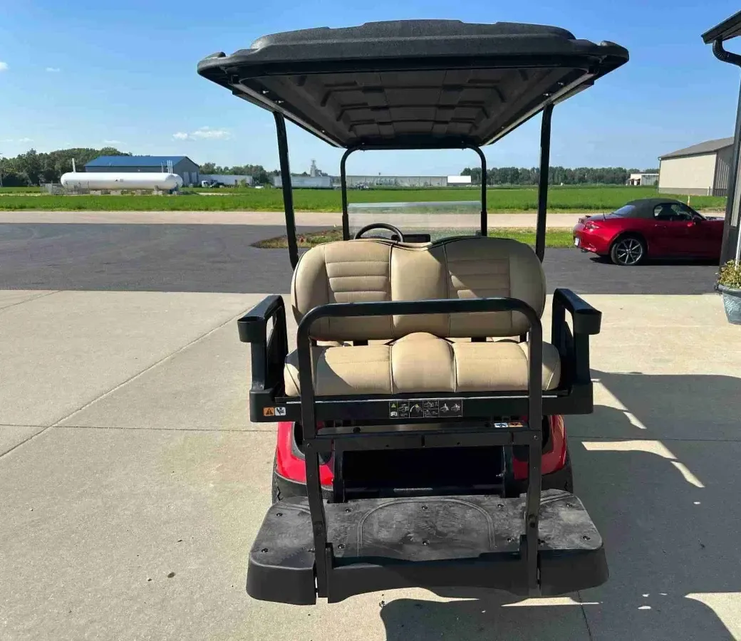 Rear view of the E-Z-GO Express 6 Touring ST showing the rear-facing seat and grab bar